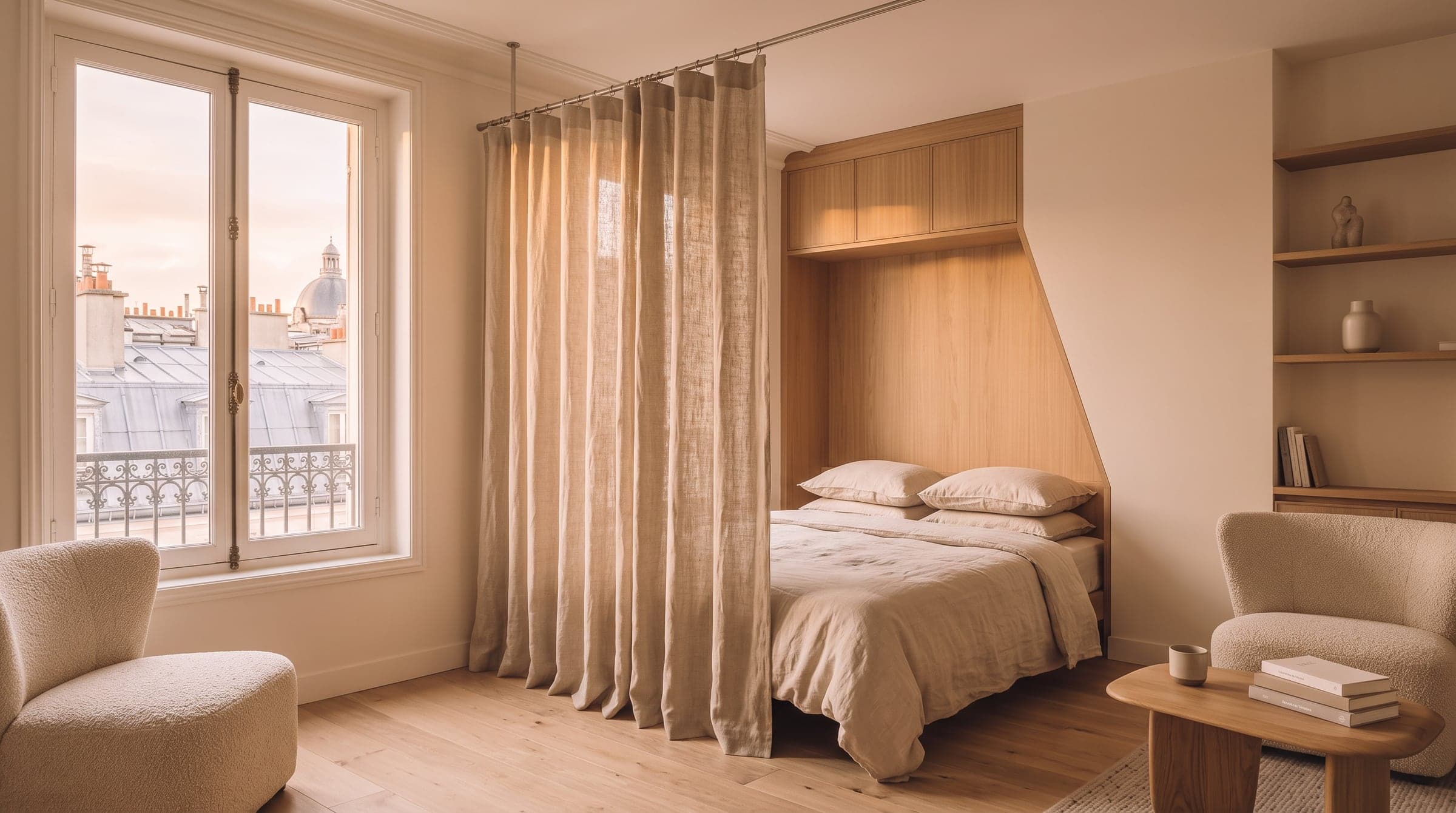 Linen curtain on a slim rod dividing a rented studio's sleeping corner from the living area, soft evening light on oak floorboards